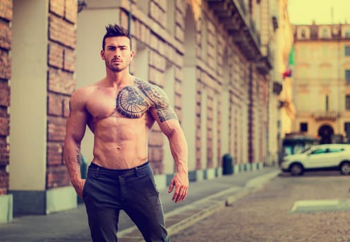 A man with a tattoo on his arm standing in the street