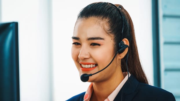 Business people wearing headset working in office to support remote customer or colleague. Call center, telemarketing, customer support agent provide service on telephone video conference call. Jivy