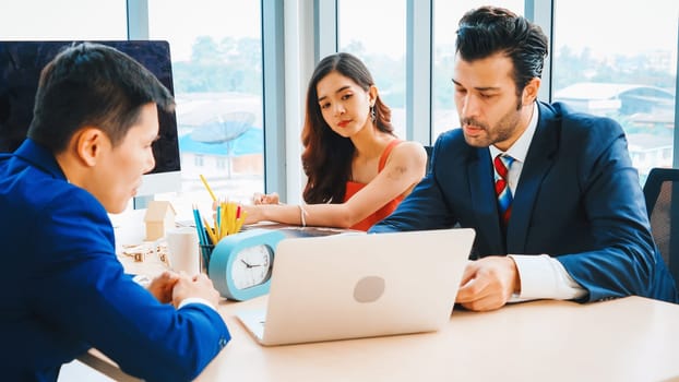 Smart businessman and businesswoman talking discussion in group meeting at office table in a modern office interior. Business collaboration strategic planning and brainstorming of coworkers. Jivy