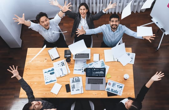 Top view office worker celebrate in meeting room, throwing paperwork in the air. Excitement and freedom expression from business people throw analysis financial paper in celebratory gesture. Concord