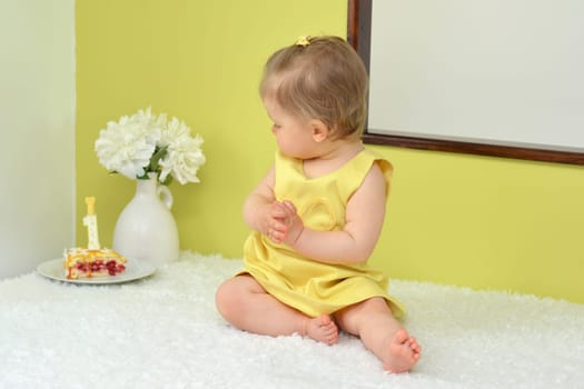 Little girl in a yellow dress celebrating first birthday