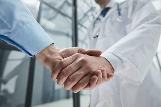 Double up on manpower to make it happen. two businessmen shaking hands during a meeting in a modern office.