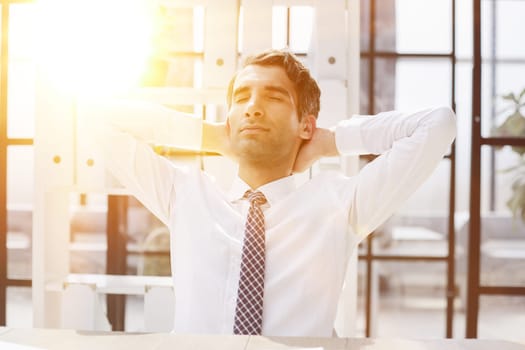 Relax, stretch and happy business man at the table in planning, work and office or work purposes.