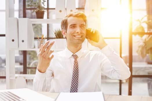Man accountant or business lawyer talking on smartphone with finance paperwork at workplace