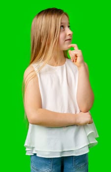 Young girl with long hair pointing upwards, showcasing her idea against a bright green background in studio