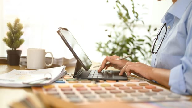 Professional interior designer or architect working with color palette design materials at desk.