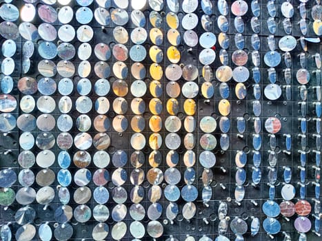 An artistic surface showcases shiny circular pieces arranged in a structured manner, creating a visually appealing texture suitable for adding text.
