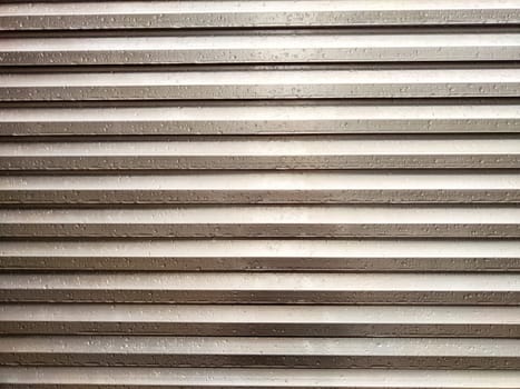 Metallic panels create a sleek backdrop adorned with soft rain droplets, offering an ideal setting for text or design elements.