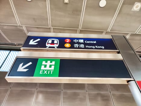 Hong Kong, China - April 09, 2024 - Passengers crowd the busy subway station in Hong Kong, following directional signs to Central and Hong Kong exits.