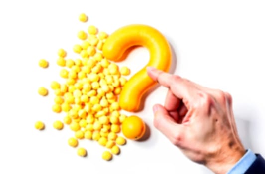 A hand gently touches a large yellow question mark surrounded by vibrant yellow balls, symbolizing inquiry about difficulties and solutions.. Blurred picture