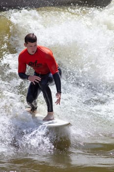 Rotterdam, Netherlands – August 5, 2024: Surfer at outdoor artificial surf pool RIF010 in the city center of Rotterdam in the Netherlands