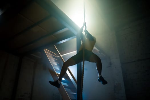 A dynamic image captures a determined person climbing a tall pole in a gym, showcasing remarkable strength and focus
