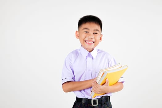 Portrait smile Asian little boy primary posing hand holding book studio isolated white background, happy cute man kid wear school uniform plaid, back to school concept