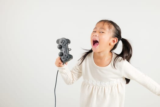 Asian happy portrait young kid girl smile lifestyle games technology holding joystick game playing on hands studio shot isolated white background with copy space, kindergarten child relaxation time