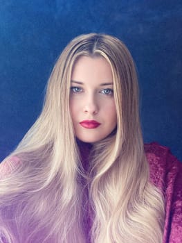 Woman, poised and captivating, with long golden hair and red lips. Velvet texture and deep blue background, radiating elegance and timeless beauty look