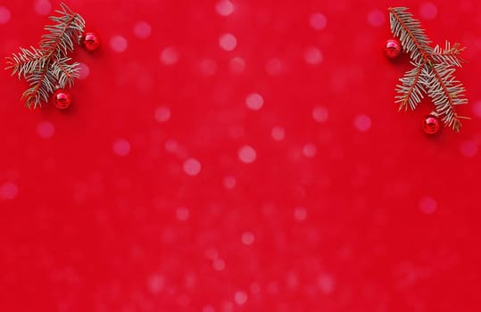 Weihnachtlicher roter Hintergrund mit Tannenzweigen, Christbaumkugeln und Schneeflocken