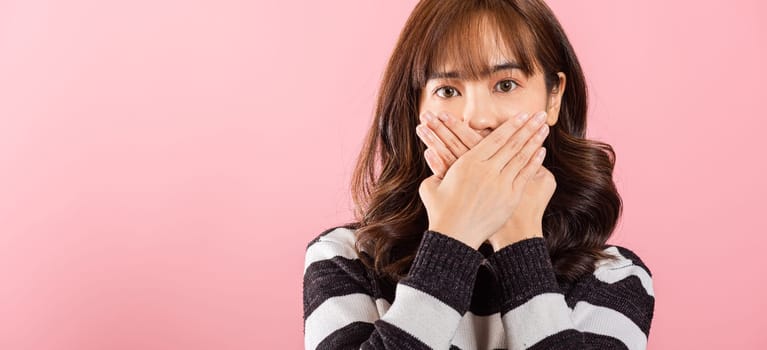Asian happy portrait beautiful young woman standing smiling surprised excited her covering mouth with hands and looking to camera on pink background with copy space for text