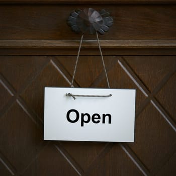 Sign on an entrance door with the English word open