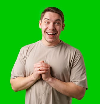 A cheerful man with a friendly smile poses against a bright green background in studio