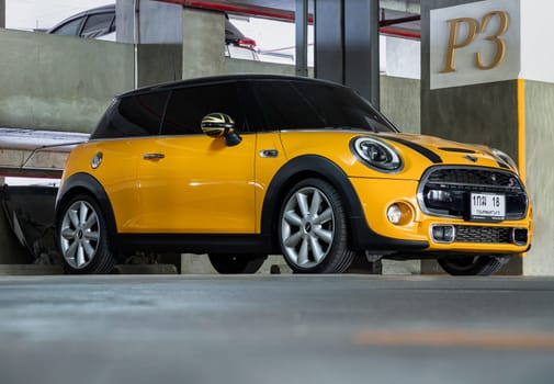 Bangkok, Thailand - 18 Jan 2025 - View of Yellow mini cooper parked parked in the parking lot of condominium building. Mini cooper is British car brands, use it as your Wallpaper, Poster and Space for text, Selective focus.