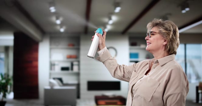 Close-up Of A Person's Hand Spraying Air Freshener In Living Room