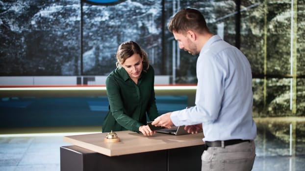 Man At Hotel Talking To Receptionist Woman. Travel Vacation Lifestyle