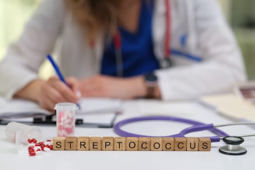 A skilled healthcare professional observes and notes important details focusing on Streptococcus bacteria at the table
