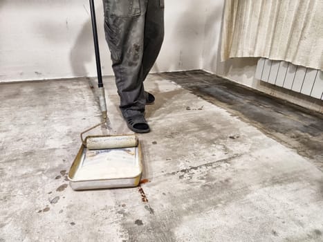 Repair work involves priming the floor in preparation for tile installation in a residential setting, ensuring a strong foundation.