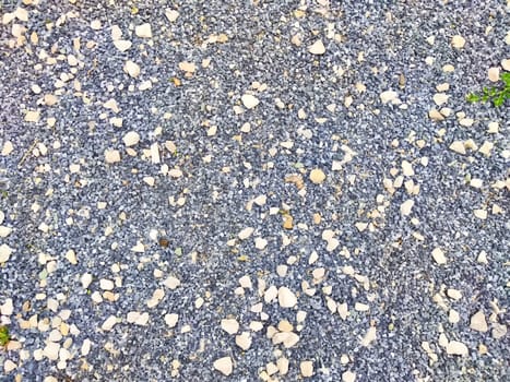 A ground covered with textured gravel and small stones creates a natural outdoor surface in a serene environment.