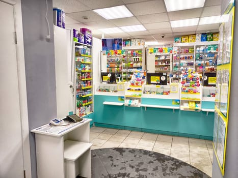 Kirov, Russia - December 11, 2024: Brightly lit pharmacy interior showing shelves stocked with medicine, health products, and a service counter for customer assistance.