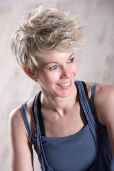 Portrait of single athletic beautiful blond woman smiling and looking sideways over stone marble background