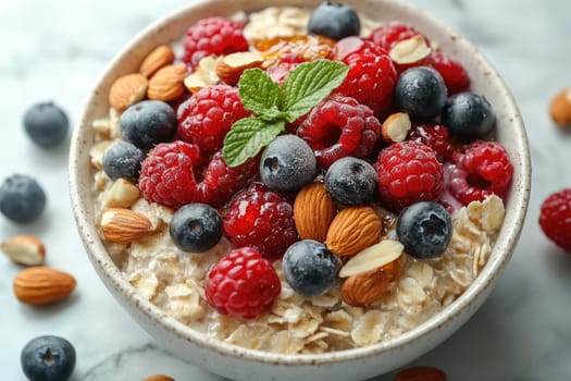 A bowl of oatmeal is beautifully presented, topped with vibrant raspberries, blueberries, and nuts. Fresh mint leaves add a pop of color to the healthy breakfast option.