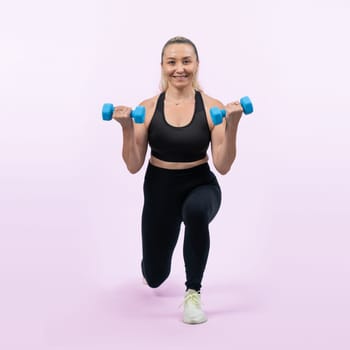 Full body length shot active and sporty senior woman lifting dumbbell during weight training workout on isolated background. Healthy active physique and body care lifestyle for pensioner. Clout