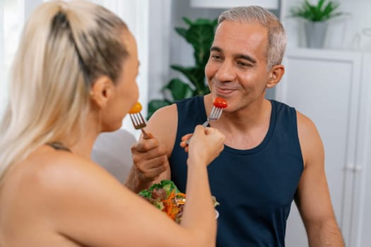 Healthy senior couple in sportswear with a bowl of fruit and vegetable. Healthy cuisine nutrition and vegan lifestyle for fitness body physique concept. Clout