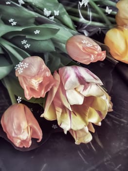 A bouquet of beautiful red, pink and yellow tulips on the table. Presented in close-up. View from above.