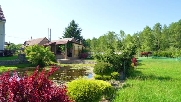 Landscape with a large gray residential building on a picturesque day with clear blue skies. House in a rural area with majestic nature.