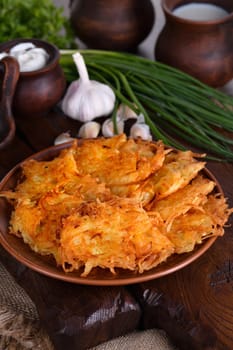 Potato fritters (a pancake, especially one made with grated potato) served with sour cream, herbs and a jug of milk. Country style.