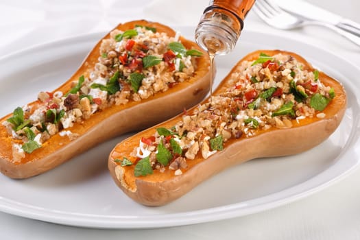 Baked stuffed pumpkin filled with walnuts, fresh mint and chili with quinoa tabbouleh. The maple syrup makes them excellent. It is a healthy side dish or main dish for vegans and paleo.