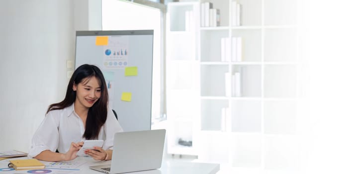 Businesswoman using a calculator to calculate numbers on a company's financial documents, she is analyzing historical financial data to plan how to grow the company. Financial concept.