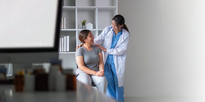 Overweight fat woman having consultation at the office. Portrait of friendly smiling doctor putting hand on shoulder supporting patient, giving consultation during medical examination in clinic.