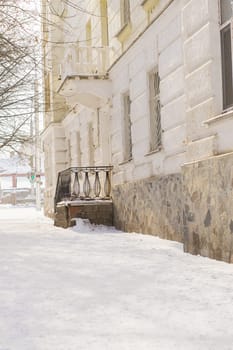 Street with houses cold weather. Snow day in winter. Building in city center covered with snow