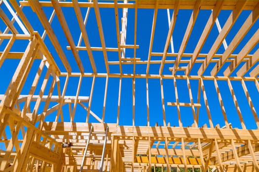 Wooden support beams in frame trusses roof construction for new house