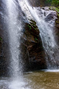 Water from the waterfall splashing through the rocks into a water well in Minas Gerais, Brazil