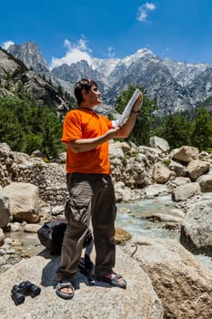 Hiker trekker studying map route on trek in Himalayas mountains. Himachal Pradesh,India