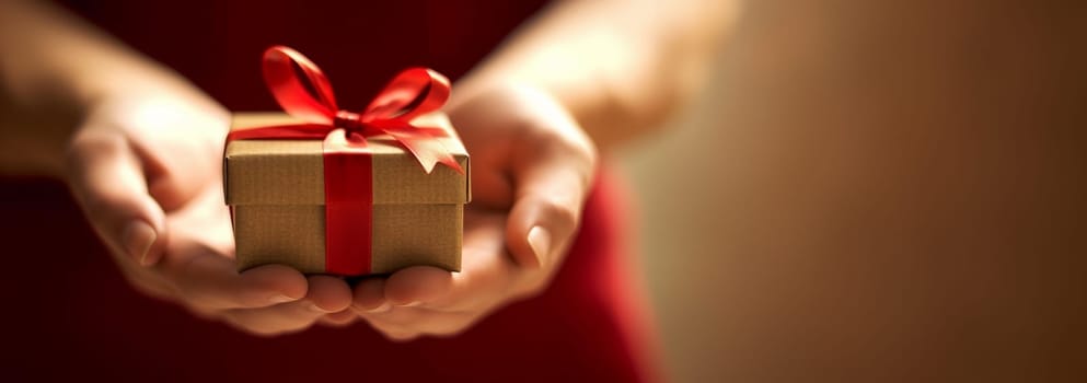 New Year and Christmas background. Female hands holds gift with red ribbon Front view, web banner. Close up hands holding present. Birthday,Christmas,Mothers Day Holiday concept Festive