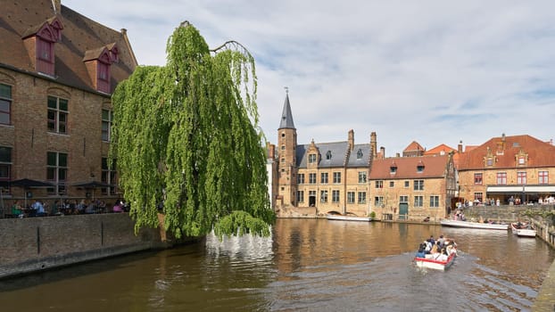 Bruges, Belgium – May 13, 2024: Canal at Rozenhoedkaai, in the old town of Bruges in Belgium with excursion boats for tourists