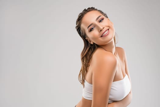 Beautiful brunette in sexy top smiling tenderly cropped portrait