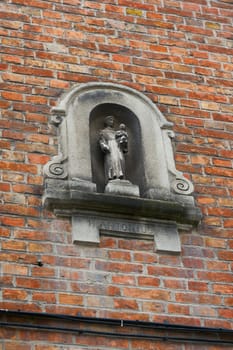 Depiction of St. Anthony on the facade of a house in the old town of Bruges in Belgium