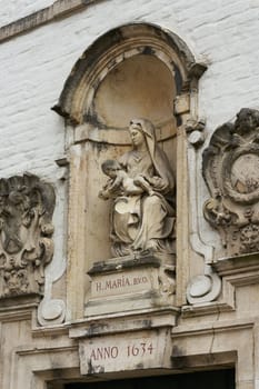 Sculpture of the Virgin Mary with Child on the facade of a house in the old town of Bruges in Belgium