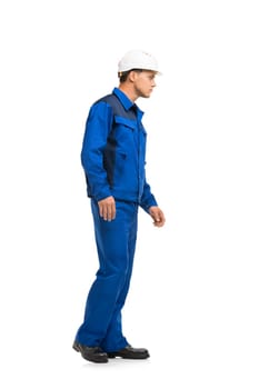 Man in blue work costume and helmet isolated full-length profile view